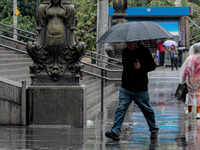 Pedestrians are protecting themselves from the rain in the central region of Sao Paulo, Brazil, on Friday, August 9. (