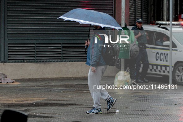 Pedestrians are protecting themselves from the rain in the central region of Sao Paulo, Brazil, on Friday, August 9. 