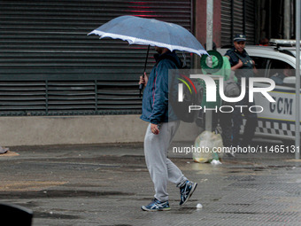 Pedestrians are protecting themselves from the rain in the central region of Sao Paulo, Brazil, on Friday, August 9. (