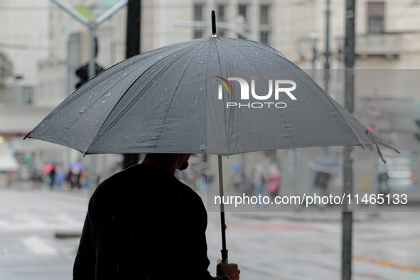 Pedestrians are protecting themselves from the rain in the central region of Sao Paulo, Brazil, on Friday, August 9. 