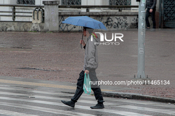 Pedestrians are protecting themselves from the rain in the central region of Sao Paulo, Brazil, on Friday, August 9. 