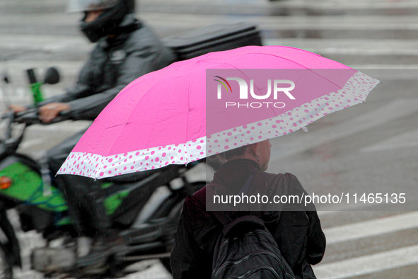 Pedestrians are protecting themselves from the rain in the central region of Sao Paulo, Brazil, on Friday, August 9. 