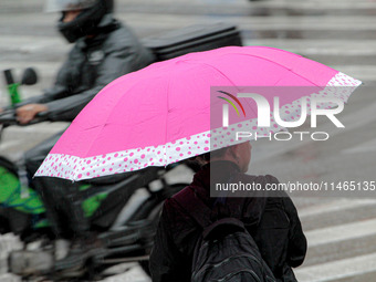 Pedestrians are protecting themselves from the rain in the central region of Sao Paulo, Brazil, on Friday, August 9. (