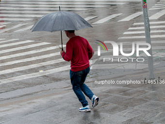 Pedestrians are protecting themselves from the rain in the central region of Sao Paulo, Brazil, on Friday, August 9. (