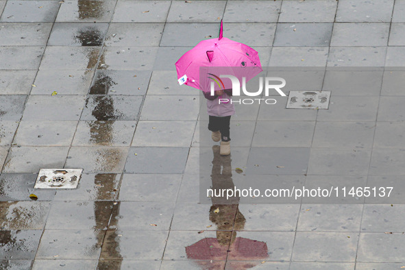 Pedestrians are protecting themselves from the rain in the central region of Sao Paulo, Brazil, on Friday, August 9. 