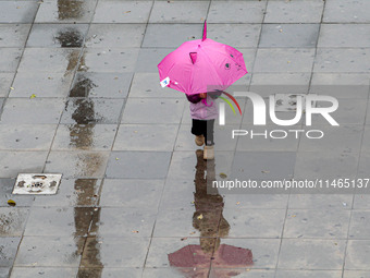 Pedestrians are protecting themselves from the rain in the central region of Sao Paulo, Brazil, on Friday, August 9. (