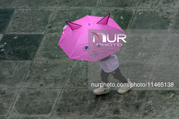 Pedestrians are protecting themselves from the rain in the central region of Sao Paulo, Brazil, on Friday, August 9. 