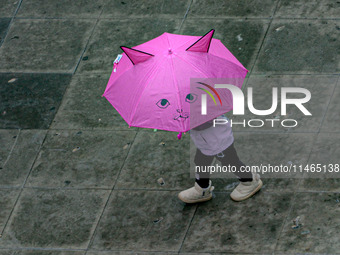 Pedestrians are protecting themselves from the rain in the central region of Sao Paulo, Brazil, on Friday, August 9. (