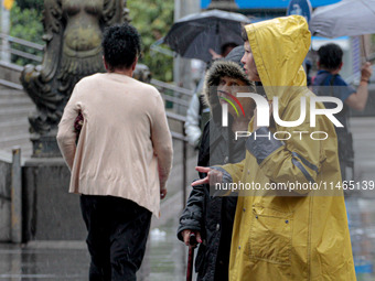 Pedestrians are protecting themselves from the rain in the central region of Sao Paulo, Brazil, on Friday, August 9. (