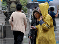 Pedestrians are protecting themselves from the rain in the central region of Sao Paulo, Brazil, on Friday, August 9. (