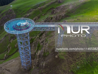 Tourists are experiencing a glass walkway at Pingding Mountain Scenic area in Mulei Kazak Autonomous county, Changji Hui Autonomous prefectu...