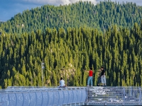 Tourists are experiencing a glass walkway at Pingding Mountain Scenic area in Mulei Kazak Autonomous county, Changji Hui Autonomous prefectu...