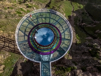 Tourists are experiencing a glass walkway at Pingding Mountain Scenic area in Mulei Kazak Autonomous county, Changji Hui Autonomous prefectu...