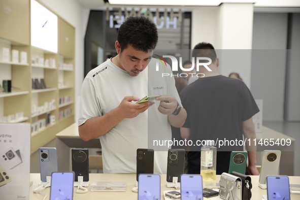 People are shopping for a Huawei nova Flip foldable mobile phone at a Huawei mobile phone store in Xi'an, Shaanxi province, China, on August...