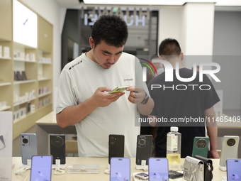 People are shopping for a Huawei nova Flip foldable mobile phone at a Huawei mobile phone store in Xi'an, Shaanxi province, China, on August...