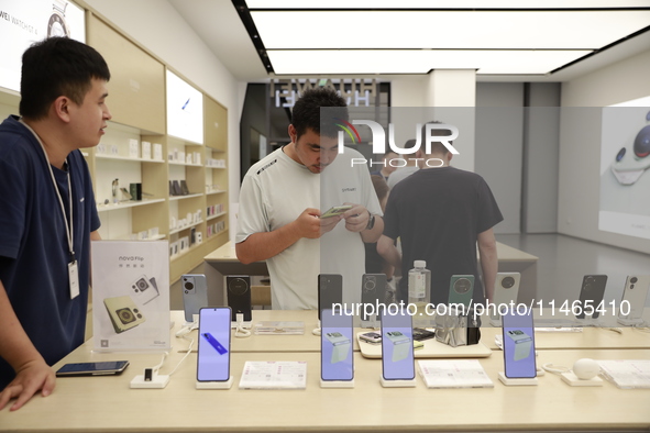 People are shopping for a Huawei nova Flip foldable mobile phone at a Huawei mobile phone store in Xi'an, Shaanxi province, China, on August...