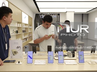 People are shopping for a Huawei nova Flip foldable mobile phone at a Huawei mobile phone store in Xi'an, Shaanxi province, China, on August...