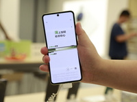 People are shopping for a Huawei nova Flip foldable mobile phone at a Huawei mobile phone store in Xi'an, Shaanxi province, China, on August...