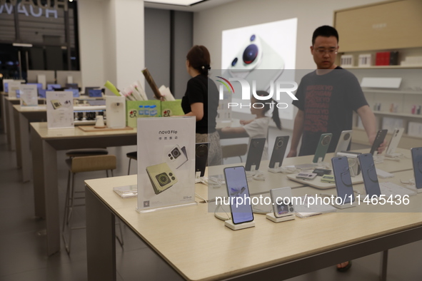 People are shopping for a Huawei nova Flip foldable mobile phone at a Huawei mobile phone store in Xi'an, Shaanxi province, China, on August...