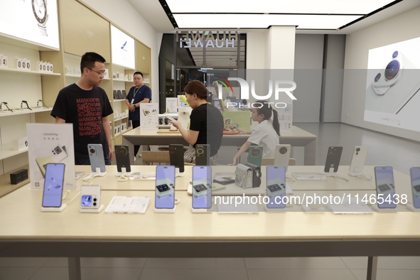 People are shopping for a Huawei nova Flip foldable mobile phone at a Huawei mobile phone store in Xi'an, Shaanxi province, China, on August...