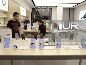 People are shopping for a Huawei nova Flip foldable mobile phone at a Huawei mobile phone store in Xi'an, Shaanxi province, China, on August...