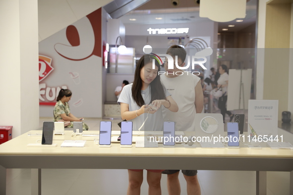 People are shopping for a Huawei nova Flip foldable mobile phone at a Huawei mobile phone store in Xi'an, Shaanxi province, China, on August...