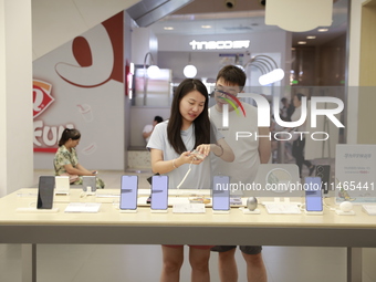 People are shopping for a Huawei nova Flip foldable mobile phone at a Huawei mobile phone store in Xi'an, Shaanxi province, China, on August...