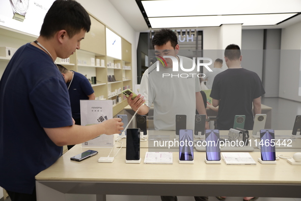 People are shopping for a Huawei nova Flip foldable mobile phone at a Huawei mobile phone store in Xi'an, Shaanxi province, China, on August...