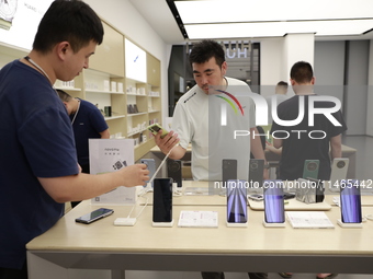 People are shopping for a Huawei nova Flip foldable mobile phone at a Huawei mobile phone store in Xi'an, Shaanxi province, China, on August...