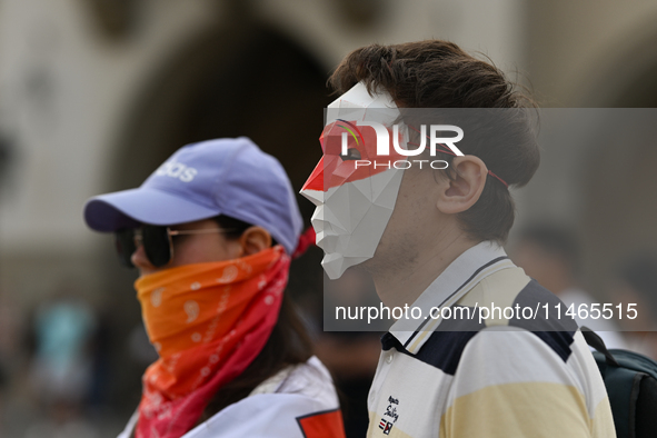 KRAKOW, POLAND - AUGUST 9:
Members of the Belarusian diaspora, wearing masks to maintain anonymity, gather at Krakow's Market Square for the...