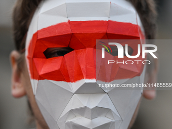 KRAKOW, POLAND - AUGUST 9:
Members of the Belarusian diaspora, wearing masks to maintain anonymity, gather at Krakow's Market Square for the...