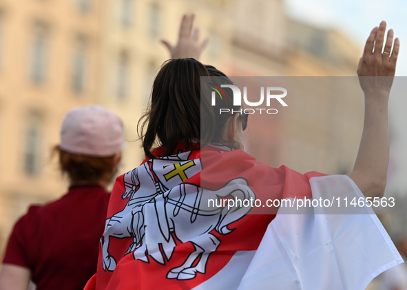 KRAKOW, POLAND - AUGUST 9:
A member of the Belarusian diaspora displaying white-red-white opposition flags during the Day of Solidarity with...