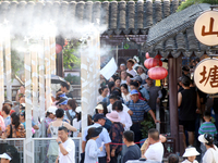 Tourists are waiting to board a boat at a cruise terminal installed with spray cooling devices in Suzhou, China, on August 8, 2024. (