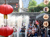 Tourists are waiting to board a boat at a cruise terminal installed with spray cooling devices in Suzhou, China, on August 8, 2024. (