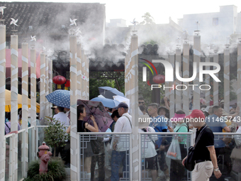 Tourists are waiting to board a boat at a cruise terminal installed with spray cooling devices in Suzhou, China, on August 8, 2024. (