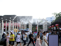 Tourists are waiting to board a boat at a cruise terminal installed with spray cooling devices in Suzhou, China, on August 8, 2024. (