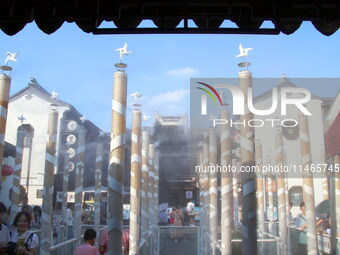 Tourists are waiting to board a boat at a cruise terminal installed with spray cooling devices in Suzhou, China, on August 8, 2024. (