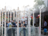 Tourists are waiting to board a boat at a cruise terminal installed with spray cooling devices in Suzhou, China, on August 8, 2024. (