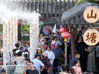 Tourists are waiting to board a boat at a cruise terminal installed with spray cooling devices in Suzhou, China, on August 8, 2024. (