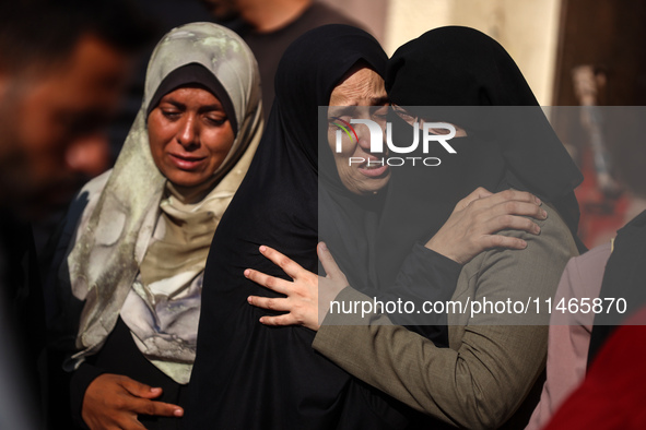 Palestinians are mourning by the bodies of relatives killed in Israeli bombardment on Nuseirat in the central Gaza Strip at Al-Aqsa Martyrs...