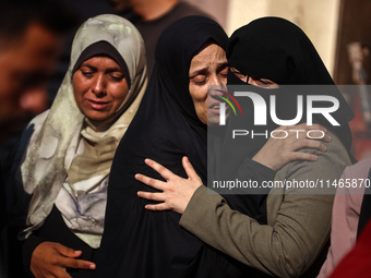 Palestinians are mourning by the bodies of relatives killed in Israeli bombardment on Nuseirat in the central Gaza Strip at Al-Aqsa Martyrs...