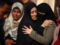 Palestinians are mourning by the bodies of relatives killed in Israeli bombardment on Nuseirat in the central Gaza Strip at Al-Aqsa Martyrs...