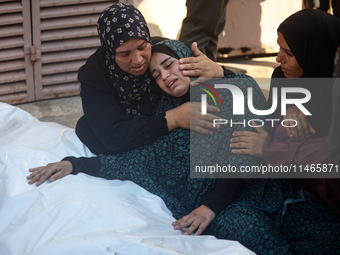 Palestinians are mourning by the bodies of relatives killed in Israeli bombardment on Nuseirat in the central Gaza Strip at Al-Aqsa Martyrs...