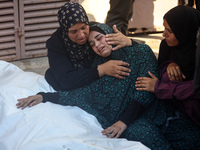 Palestinians are mourning by the bodies of relatives killed in Israeli bombardment on Nuseirat in the central Gaza Strip at Al-Aqsa Martyrs...