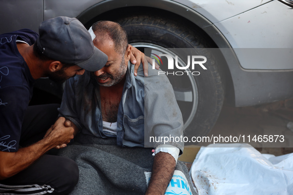 Palestinians are mourning by the bodies of relatives killed in Israeli bombardment on Nuseirat in the central Gaza Strip at Al-Aqsa Martyrs...