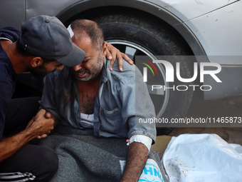 Palestinians are mourning by the bodies of relatives killed in Israeli bombardment on Nuseirat in the central Gaza Strip at Al-Aqsa Martyrs...