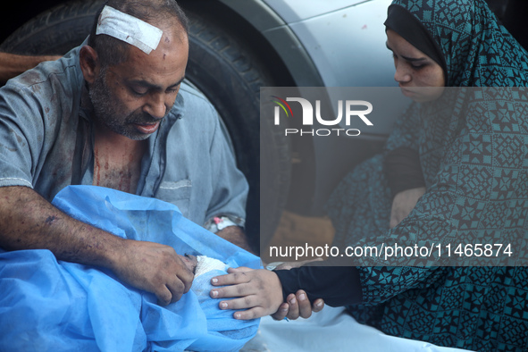 Palestinians are mourning by the bodies of relatives killed in Israeli bombardment on Nuseirat in the central Gaza Strip at Al-Aqsa Martyrs...