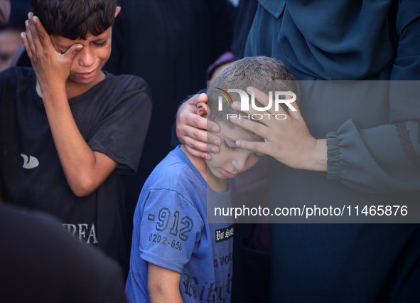 Palestinians are mourning by the bodies of relatives killed in Israeli bombardment on Nuseirat in the central Gaza Strip at Al-Aqsa Martyrs...