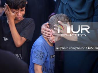 Palestinians are mourning by the bodies of relatives killed in Israeli bombardment on Nuseirat in the central Gaza Strip at Al-Aqsa Martyrs...