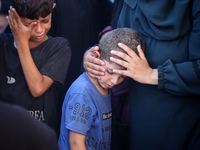 Palestinians are mourning by the bodies of relatives killed in Israeli bombardment on Nuseirat in the central Gaza Strip at Al-Aqsa Martyrs...